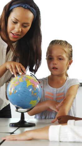 happy school kids with globe in classroom