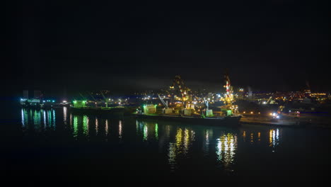 aerial night timelapse of cranes unloading nickel ore from ship