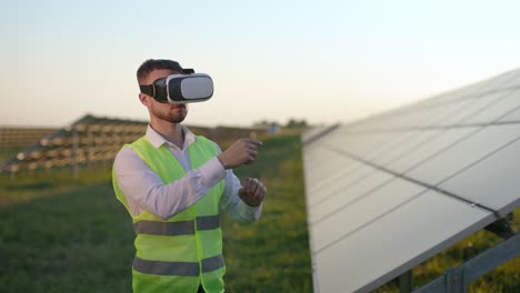 male worker in vr headset standing field with solar panels.