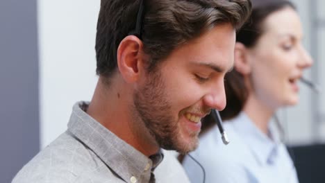 Smiling-customer-service-executives-talking-on-headset-at-desk-4k