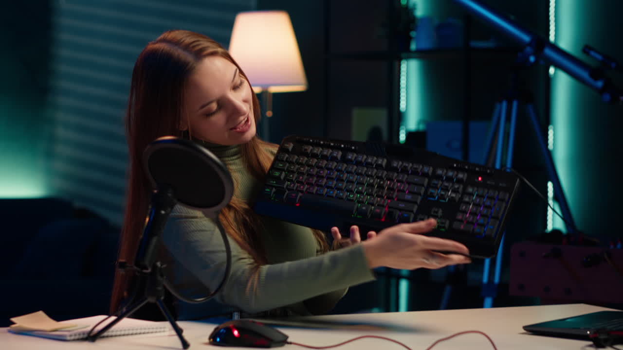 유쾌한 미디어 스타가 청중에게 컴퓨터 주변 장치의 기능을 보여줍니다.