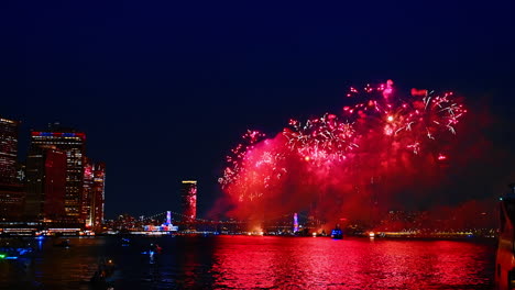 flashes of spectacular fireworks over the river at night. new york celebration with a fantastic show. view from the riverscape