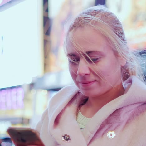 Mujer-Joven-En-Abrigo-Rosa-Escribiendo-Sms-En-El-Teléfono