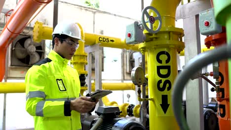 ingeniero asiático trabajando en la sala de calderas.
