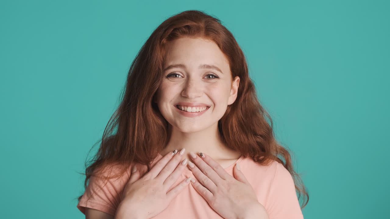 은 머리의 소녀가 카메라 앞에서 색 바탕에.