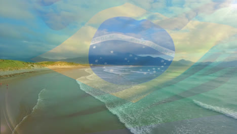 digital composition of brazil flag waving against aerial view of waves in the sea