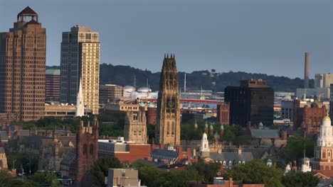 historic cathedral and harkness tower in new haven, connecticut. aerial zoom wide shot. old university and downtown buildings in center. sunrise time on peaceful morning in u.s