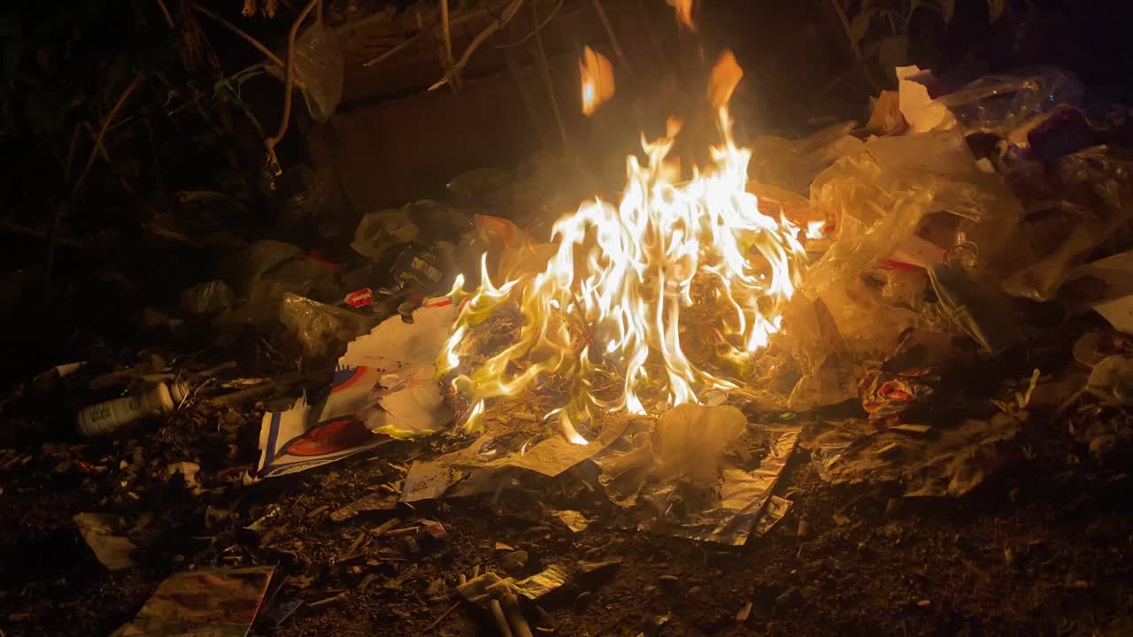 밤에 다카 거리에서 주황색 노란색 불꽃으로 타는 쓰레기