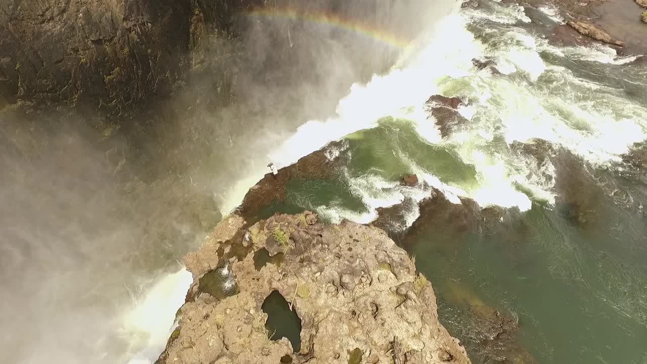 una vista aérea muestra a un turista en lo alto de las cataratas victoria en la piscina del diablo en zambia
