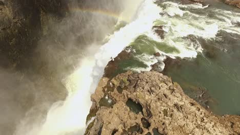 una vista aérea muestra a un turista en lo alto de las cataratas victoria en la piscina del diablo en zambia