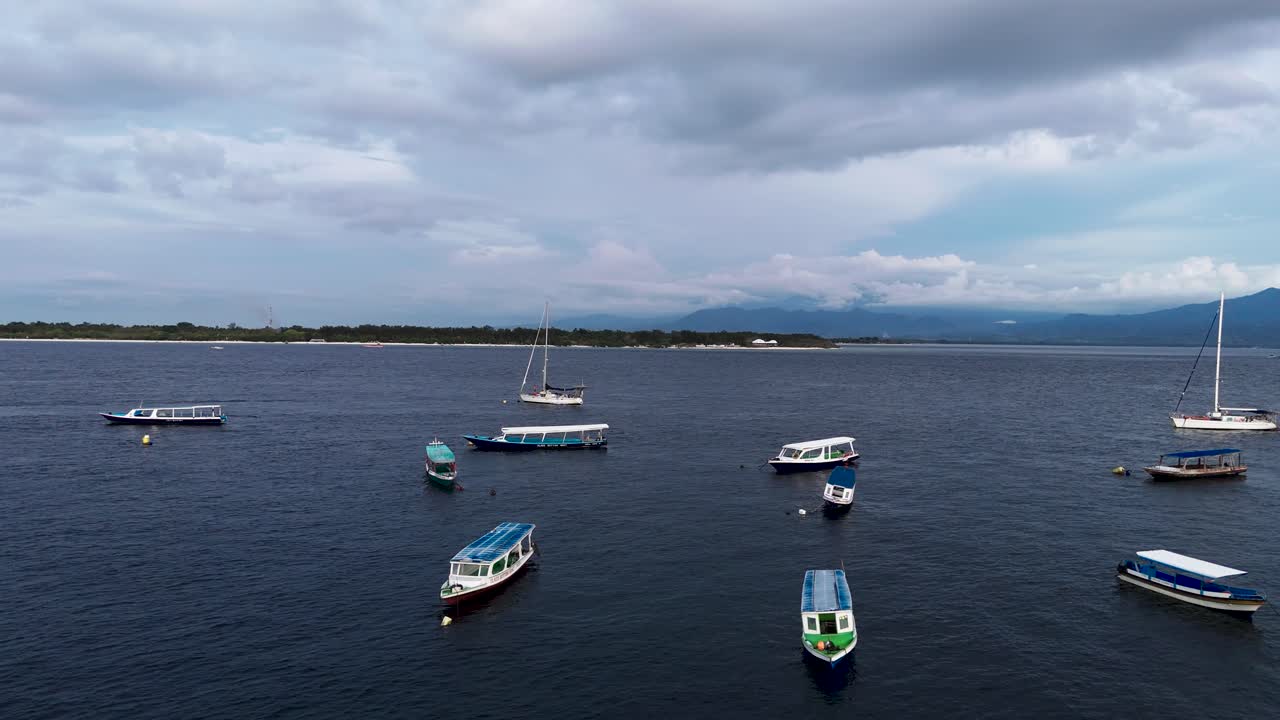 Fly low over surface at Gili islands, view of boats and sea