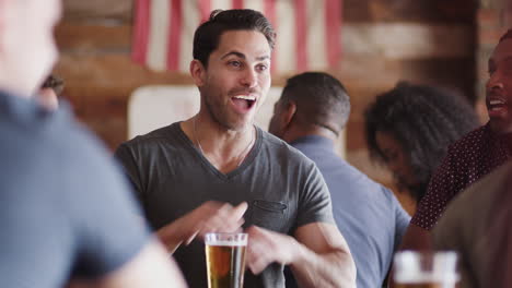 group of male friends meeting in sports bar making toast together