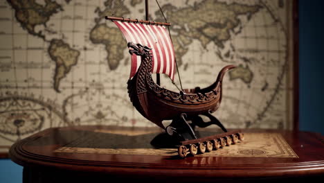 wooden viking ship model on table with old map background