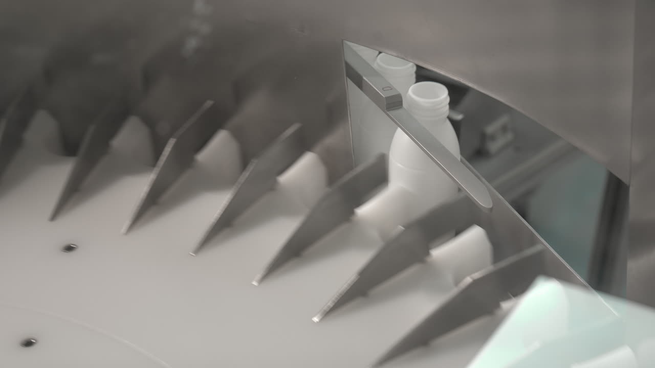 병 공급 기계는 흰색 모빌락 병을 배열합니다 - 클로즈업 샷