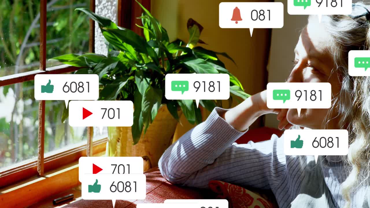 animación de iconos de las redes sociales sobre una mujer mayor caucásica mirando por la ventana de su casa