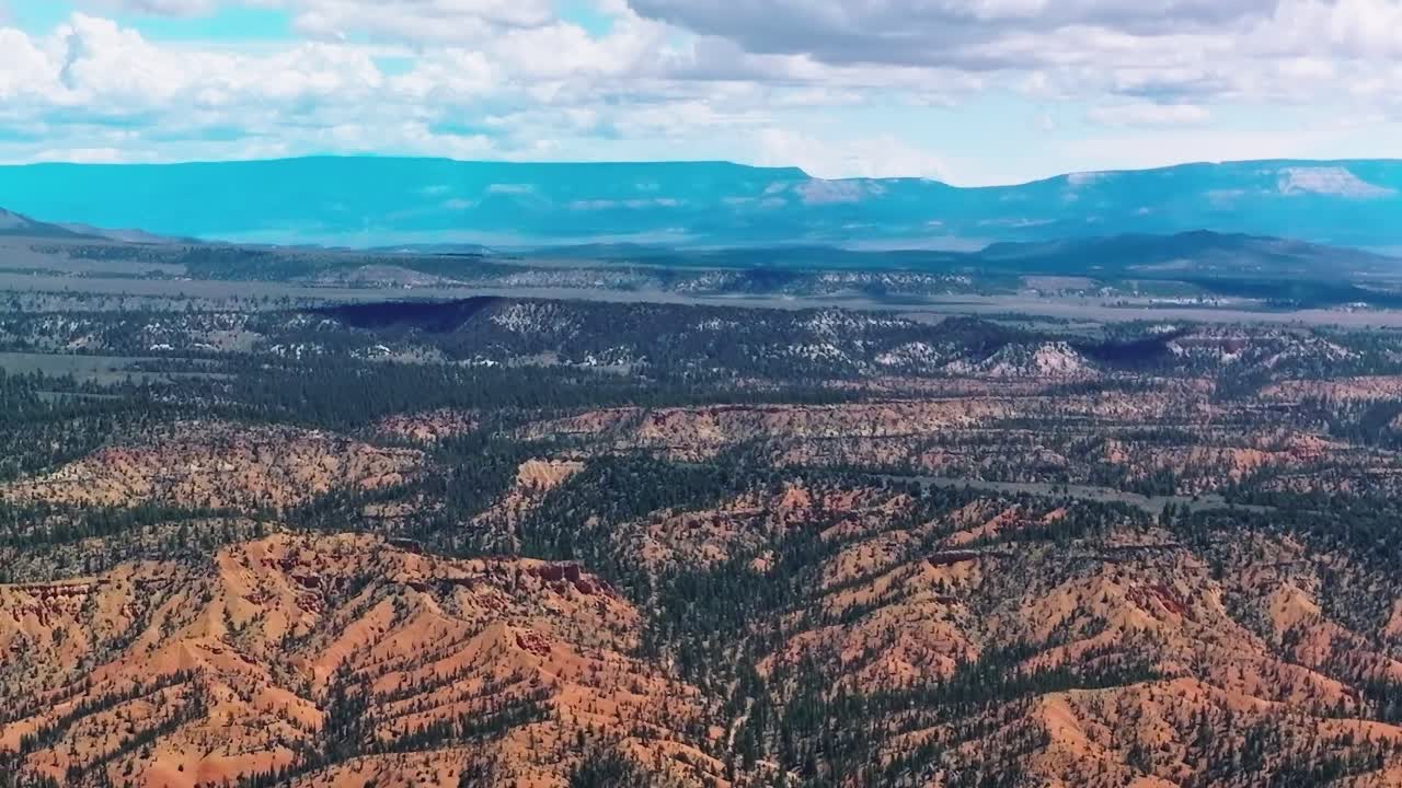 Il paesaggio del Mojave mostra un terreno desertico e montagne distanti sotto un cielo blu.