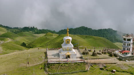 drone shot captures a nepal stupa covered in clouds surrounded by the peaceful landscape of shailung dolakha lush greenery and forests enhance atmosphere near tibet stunning natural view
