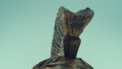 A-rotating-close-up-macro-shot-of-a-spartan-warrior-metal-bronze-ancient-greek-helmet,-with-shapes-and-forms,-studio-lighting,-slow-motion,-4K-video