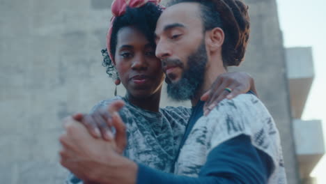 attractive couple dancing tango and posing for camera on a rooftop
