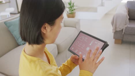 Asiatische-Frau-Benutzt-Tablet-Und-Sitzt-Auf-Der-Couch-Im-Wohnzimmer