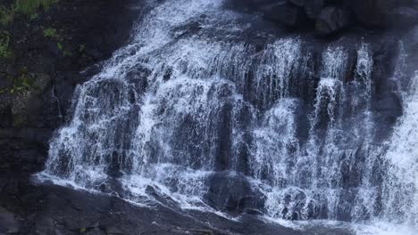 water flowing over a rocky waterfall cliff