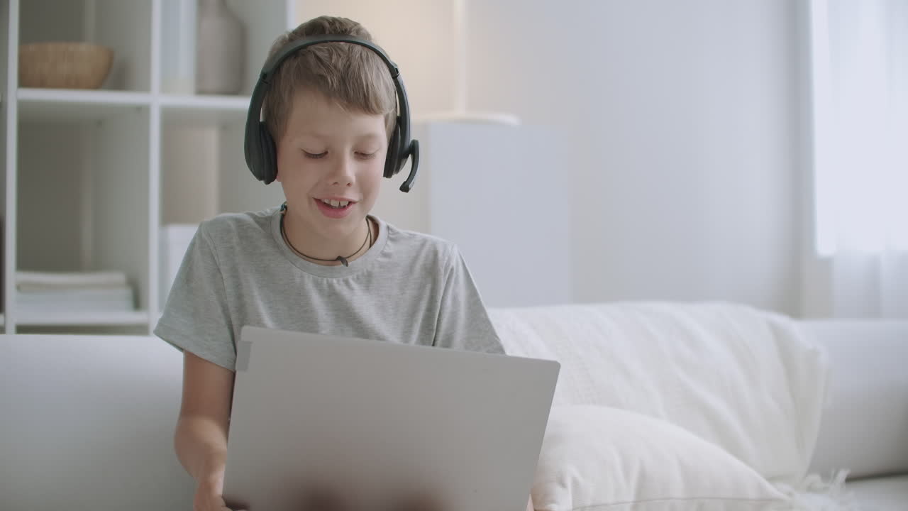 niño niño solo en casa dibujando sentado en la cama y comunicándose con amigos por computadora portátil infancia feliz