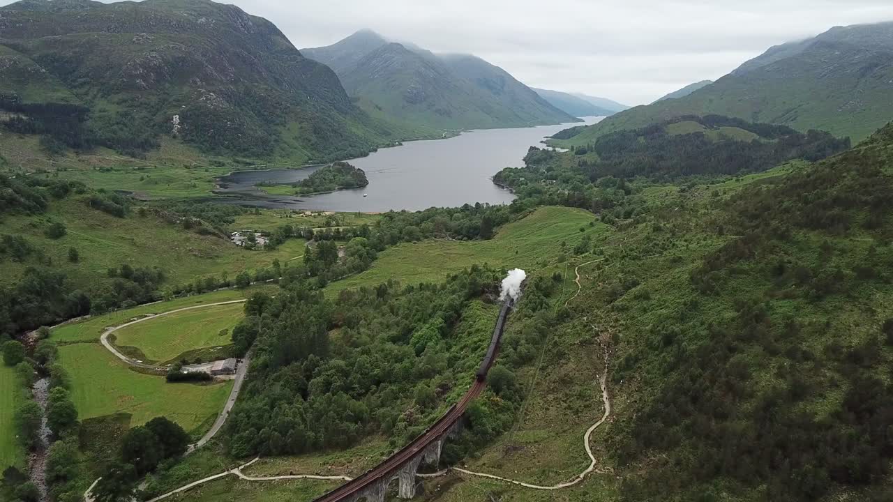 la antena sigue el tren turístico de vapor jacobita en el viaducto de glenfinnan