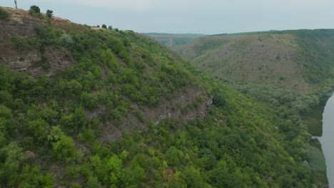 Bewegung-Vom-Rand-Des-Bergrückens-Entlang-Des-Hangs-In-Richtung-Fluss