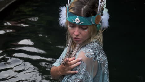 mujer con traje inspirado en los nativos junto al agua