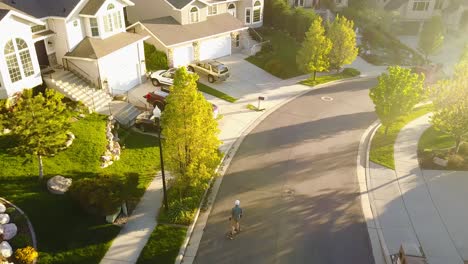 cinematic drone shot of a boy riding his skateboard down a hill going really fast and then coming to a stop by putting his hands on the ground and sliding