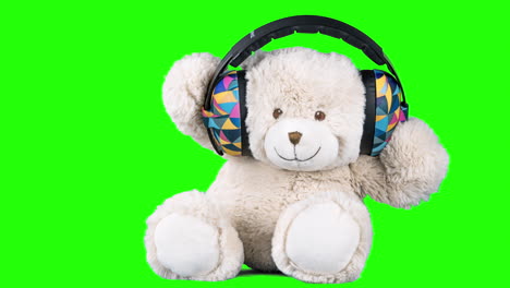 teddy bear with headphones on a green screen