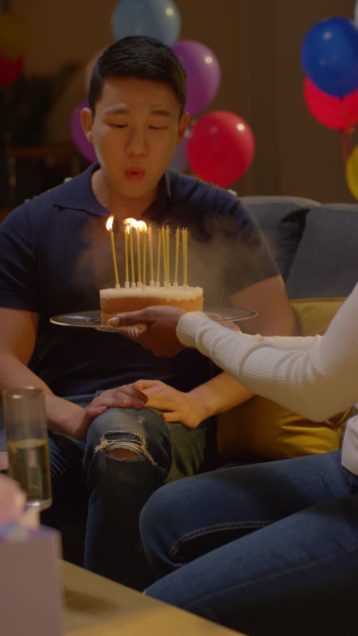 Vertical Video Of Multi-Cultural Group Celebrating Friends Birthday At Home With Cake And Candles At Party 1