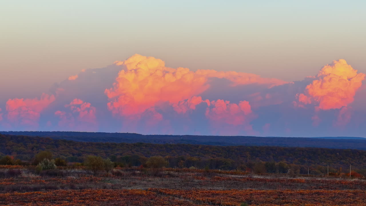 Aerial drone view of soft pink clouds above autumn vineyards and fields in rural Moldova