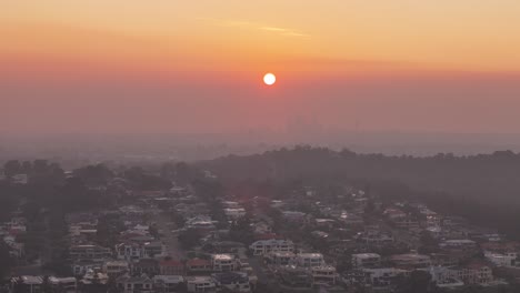 Drone-Elevándose-Sobre-Una-Propiedad-De-Lujo-En-Perth-Con-Un-Amanecer-Ahumado-En-El-Fondo-Y-La-Silueta-Del-Horizonte-De-La-Ciudad