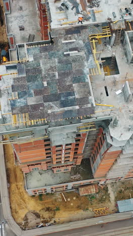 construction of a residential apartment complex. aerial view. workers on the roof. vertical video