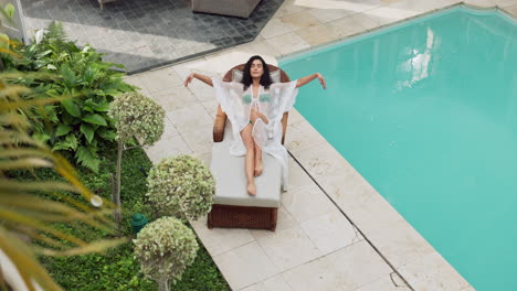 woman relaxing by the pool on a lounge chair