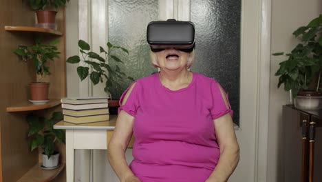 Ältere-Großmutter-Mit-Virtueller-Headset-Brille,-Die-Sich-Zu-Hause-3D-Videos-Im-360-VR-Helm-Ansieht