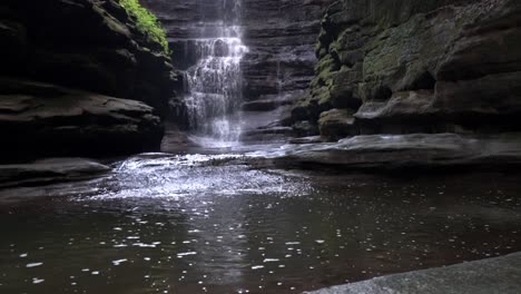 Caída-De-Agua-En-Cascada-Que-Se-Vierte-En-Una-Piscina-Rodeada-De-Roca-Lisa-Cubierta-De-Musgo-En-Roca-Hambrienta-En-El-Parque-Estatal-Matthiessen