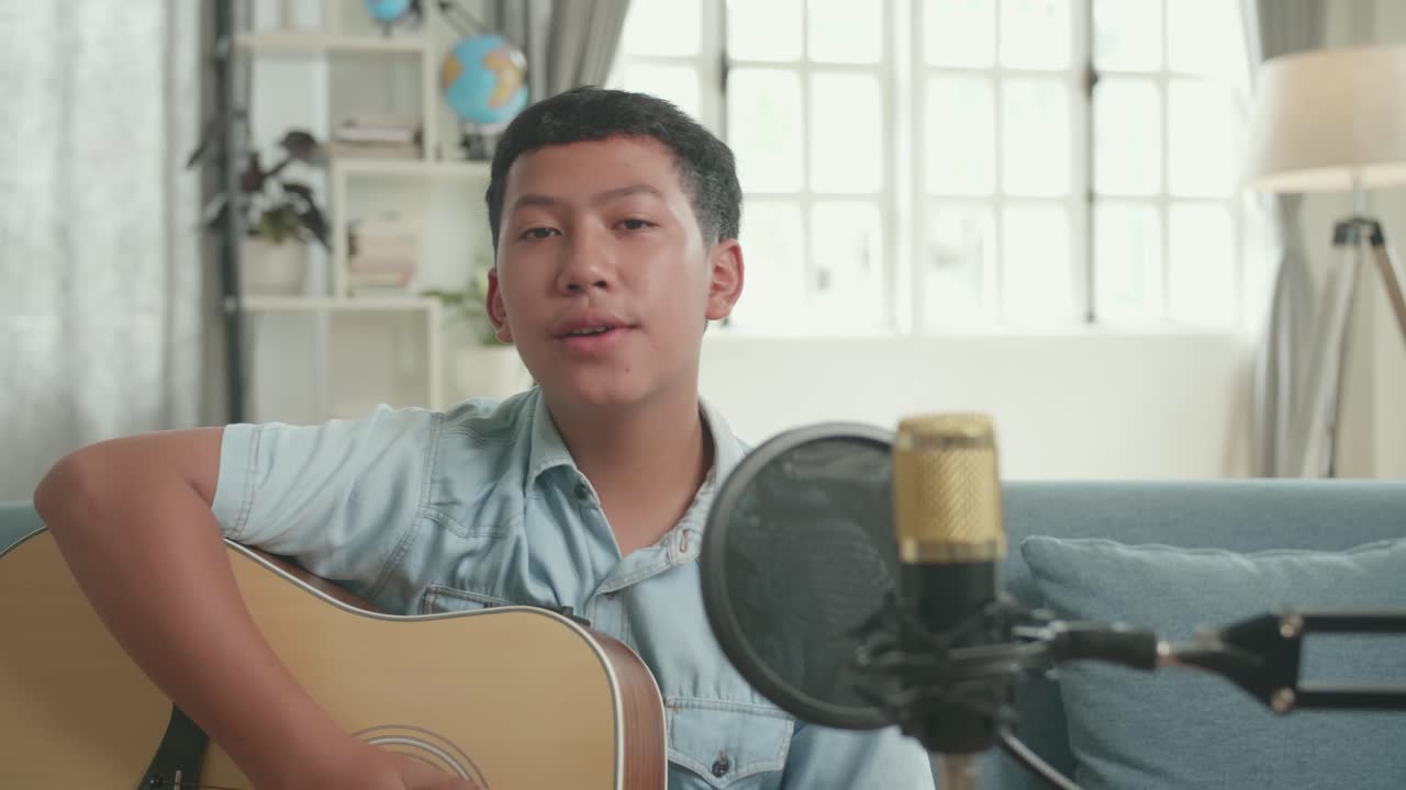 Teenage Boy Singing and Playing Guitar at Home