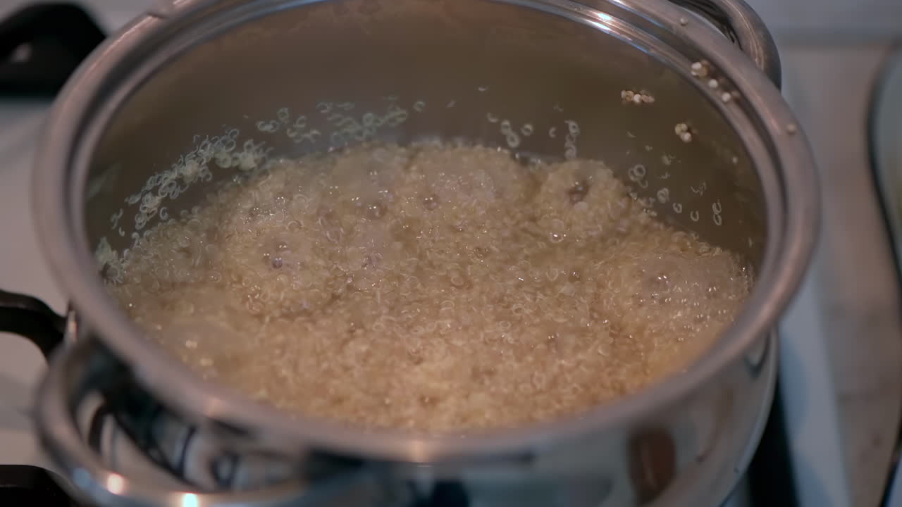 Close up of white quinoa cooking in a pot on the stove