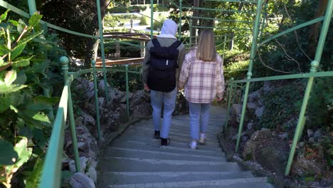 young couple walking down the stairs in the park