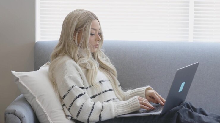 Beautiful woman working from home on a high-tech laptop in a trendy space.