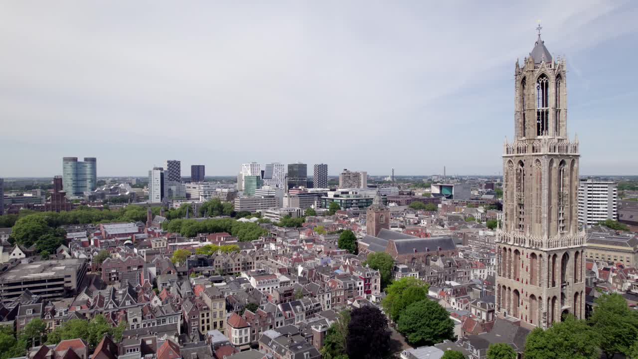 Closeup aerial view of cathedral De Dom church tower architecture of the Utrecht diocese with high rise modern contemporary buildings in the background