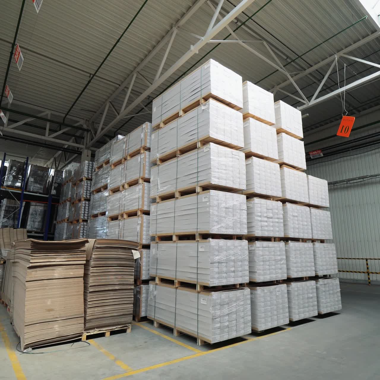 packed pallets of a parquet board stand in the warehouse at a woodworking plant. Warehouse stocks for floorboard sales