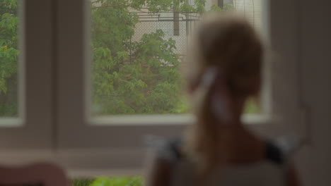 girl looking outside through the window