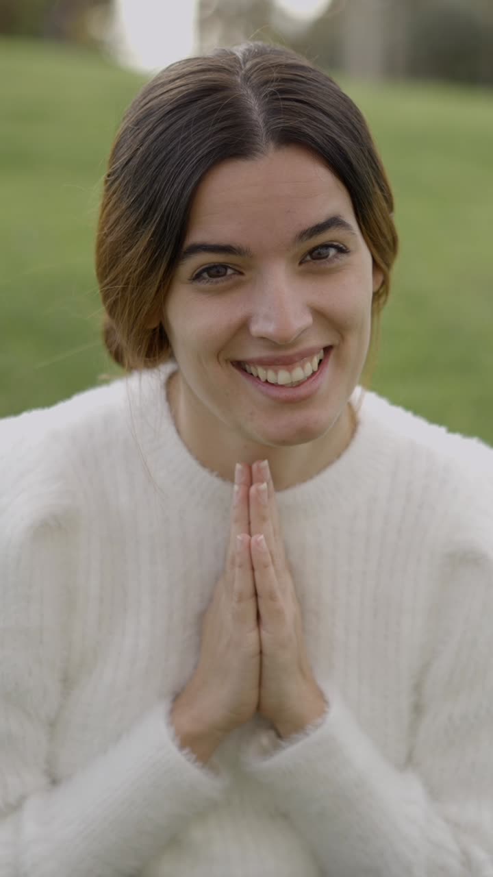 Giovane donna che supplica o prega con le mani giunte all'aperto