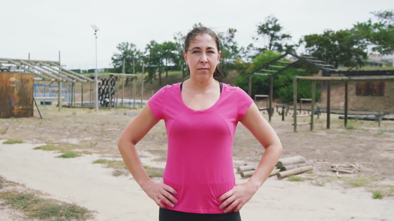 mujer caucásica mirando a la cámara en el campo de entrenamiento