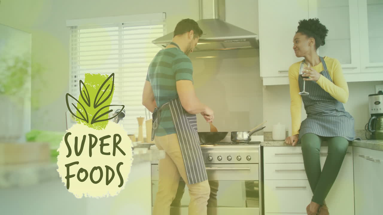 Animation of super foods text over diverse couple preparing healthy meal in kitchen