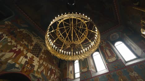 a beautiful large chandelier hangs from the ceiling in a christian church. shooting from the bottom up. cool architecture