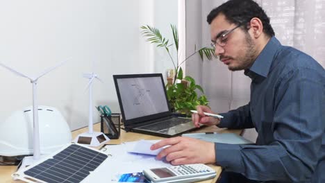 engineer comparing a blueprint with a 3d cad model on laptop